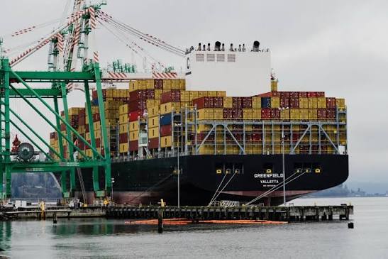 A fully loaded container ship berthed beside gantry cranes at the Port of Everett on Possession Sound
