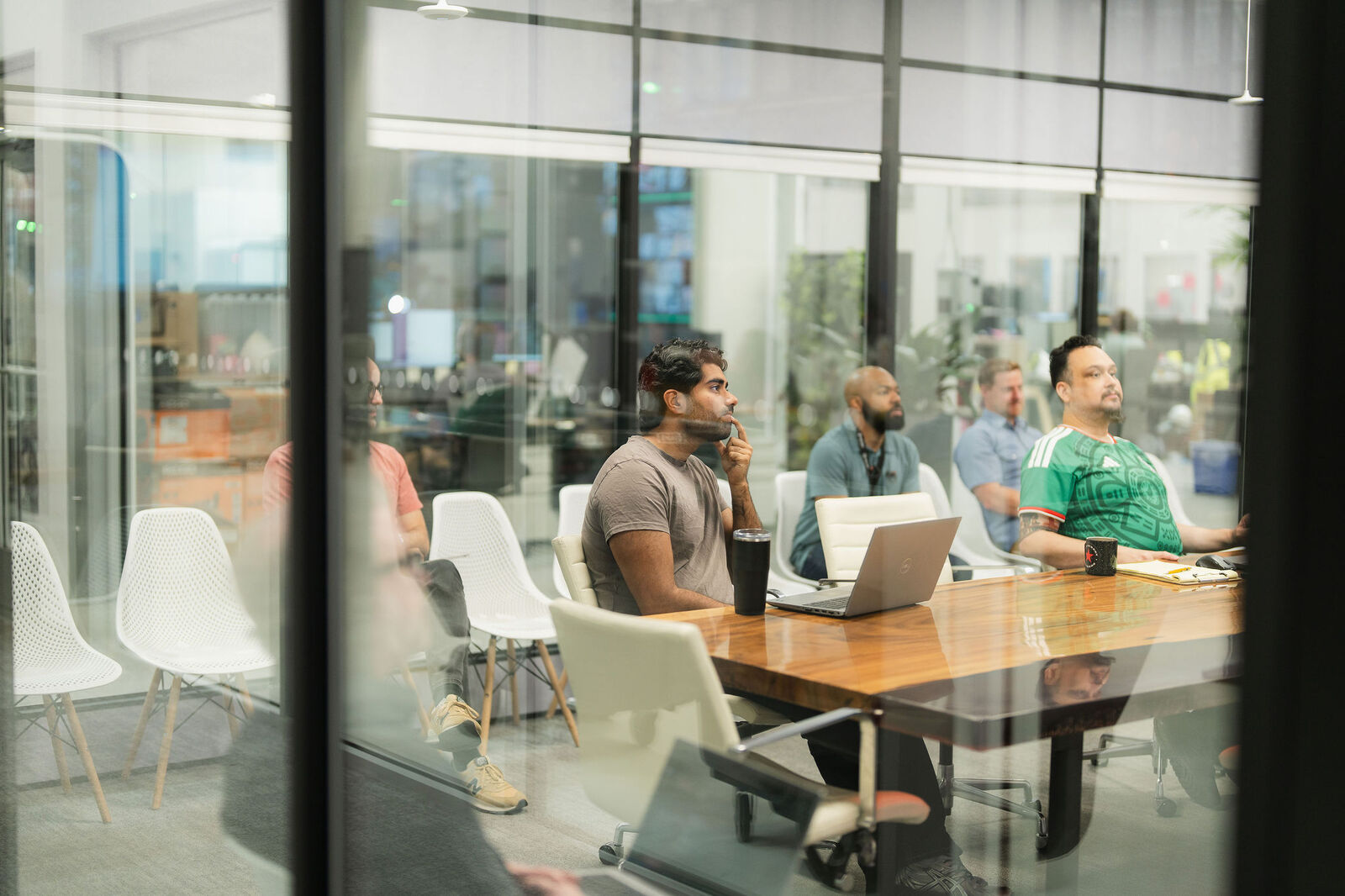 A young team collaborates around a live-edge conference table in a glass-walled Everett workspace